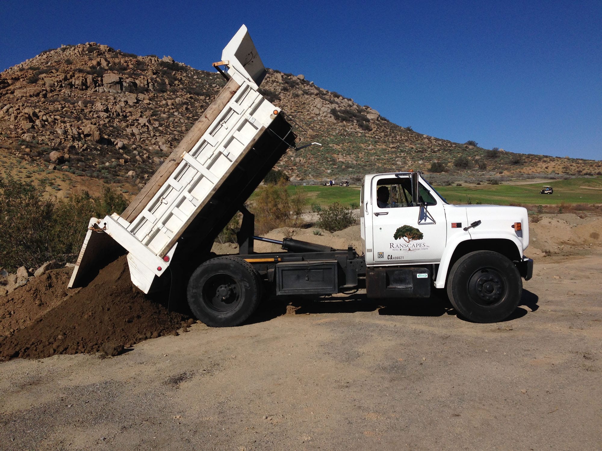 A Ranscapes truck dropping recycled mulch on a hillside